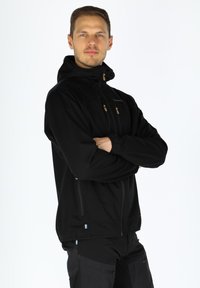 Black zip-up jacket with a hood, featuring tan accents and zippers, designed with a smooth texture and a fitted silhouette.