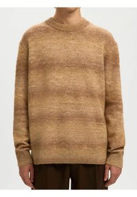 Pull tricot dégradé beige et marron clair avec poignets, ourlet et encolure ronde côtelés, porté par une personne debout devant un fond uni.