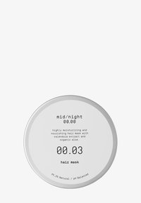 Rund metallbeholder med sølvfarget lokk. Etiketten har hvit bakgrunn og svart tekst som beskriver produktnavn og beskrivelse.