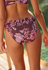 Kwiatowe bikini w ciemnym purpurze z różowymi akcentami. Posiada elastyczny pas i gładką fakturę. Zaprojektowane do użytku jako strój kąpielowy.