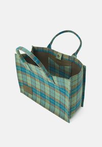 Sac à main à carreaux en mélange de laine bleu sarcelle, bleu et marron. Ouverture sur le dessus, avec deux poignées et un patch logo sur le côté. Design texturé et structuré.