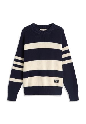 Pull en maille à rayures bleu marine et blanches, manches longues, col et poignets côtelés, avec une petite étiquette noire près de l'ourlet.