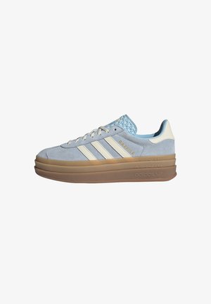 Baskets Adidas Gazelle bleu clair avec des bandes écrues et une semelle épaisse marron stratifiée, dessus en daim, fermeture à lacets.