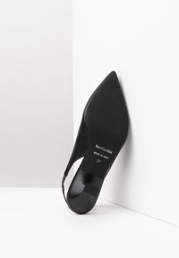 Scarpa slingback nera a punta, realizzata in tessuto morbido con superficie liscia, caratterizzata da un tacco basso e etichetta del marchio all'interno. Taglia 37.