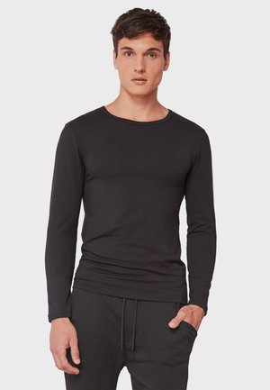 Camisa negra de manga larga con escote redondo, hecha de tela suave, con un diseño ajustado y detalles de costura sutiles.