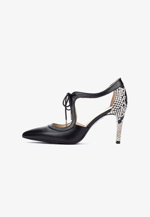 Zapato de tacón alto de cuero negro con punta puntiaguda, diseño recortado y parte delantera con cordones. La parte trasera presenta un acento texturizado con estampado de serpiente.
