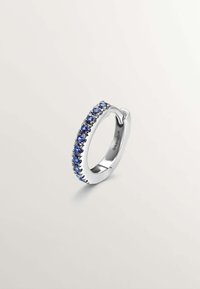 Pendiente de aro de plata con una fila de piedras preciosas azules engastadas en un ajuste de garras, con un acabado suave y pulido.