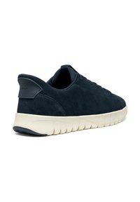 Zapatillas de ante azul marino con punta redondeada, diseño de cordones, panel lateral texturizado y suela crema en contraste con un patrón de olas.