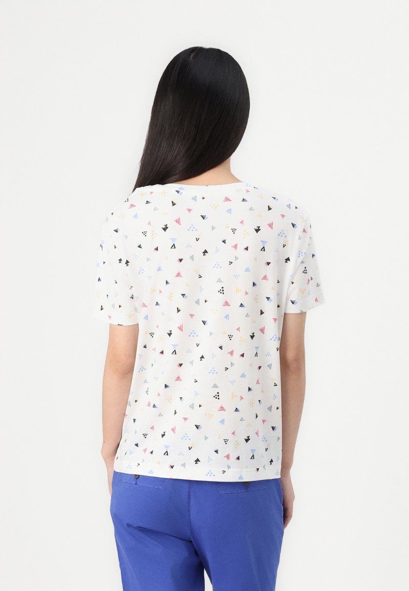 T-shirt blanc à manches courtes avec des motifs géométriques triangulaires multicolores. Il présente un col rond et une coupe décontractée.
