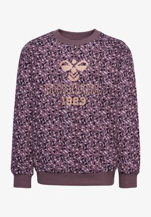 Fioletowa bluza z teksturowanym nadrukiem zwierzęcym, ze ściągaczem w okolicy szyi i mankietami. Błyszczące złote logo "HUMMEL 1923" na środku.