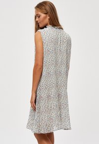 Mouwloze jurk van lichtgewicht stof, met een bloemenpatroon in pastelkleuren, een losse pasvorm en een lengte tot op de knie.