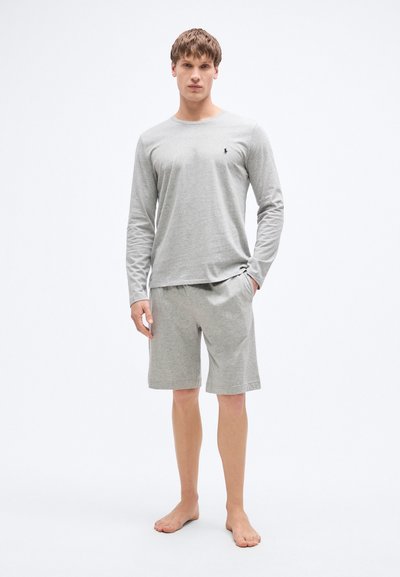 Šedé tričko s dlouhým rukávem a odpovídající šortky vyrobené z měkké látky. Na hrudi je malá logo a volný střih.