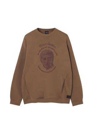 Brun crewneck-sweatshirt med et tekstureret klassisk skulpturansigt og tekst, der lyder "Miron Studios, In the eye of the beholder, Chihuahua Houston Texas."