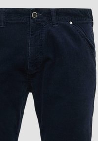 Donkere marineblauwe corduroy broek met het voorste taillegebied, inclusief knop, rits, ceintuurlussen en zijzakken.