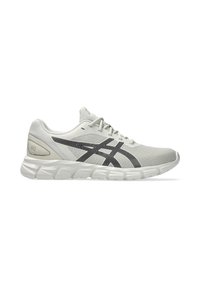 Scarpa sportiva grigio chiaro con tomaia in rete, dettagli neri e suola ammortizzata. Presenta un design testurizzato e chiusura con lacci.