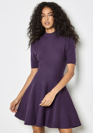 Vestido de punto morado con un cuerpo ajustado, mangas cortas y una falda acampanada. Textura suave y brillo sutil, con un diseño de cuello alto.