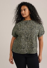 Top verde con stampa leopardata, dal fit morbido, maniche corte e scollatura rotonda. Realizzato in tessuto liscio con un leggero lucido.