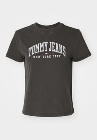 Camiseta de algodón gris oscuro con mangas cortas y un escote redondo. Presenta texto en blanco "TOMMY JEANS NEW YORK CITY" y un pequeño acento rojo.