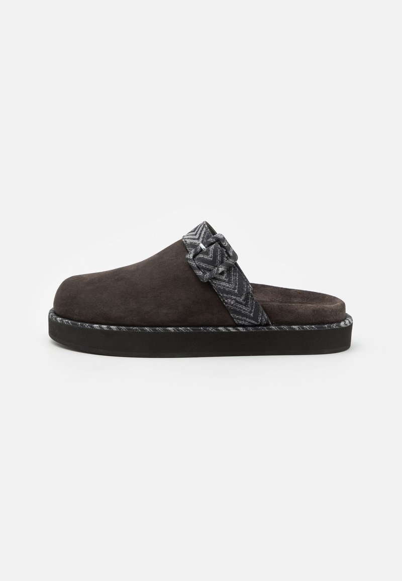 Mörkbrun mocka slip-on sko med ett mönstrat grått band och silverdetaljer. Har en tjock svart sula med texturerade kanter.