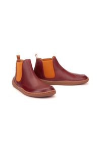 Botas de tobillo de cuero rojo con paneles elásticos naranjas en los lados, punta redondeada, suelas de goma y lengüetas para ponerlas y quitarlas fácilmente.