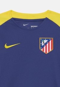 Nike treningsskjorte med slim fit. Har blått stoff, gule skulderdetaljer, rund hals og et brodert klubbmerke på brystet.