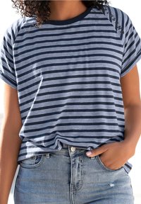 Randig T-shirt i marinblått och ljusblått, gjord av mjuk bomull. Kort ärmar, rundad hals, avslappnad passform, med rullade kanter och sidoklippdetaljer.