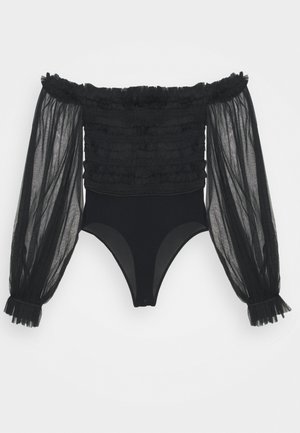 Musta olkapäältä putoava bodysuit, jossa on rypytetty yläosa ja läpinäkyvät pitkät puffihihat, jotka päättyvät rypytettyihin hihansuihin, valkoista taustaa vasten.