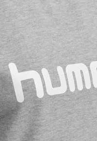 Felpa grigia con un grande e audace design del testo “hum” in bianco. Tessuto morbido con una finitura leggermente melangiata e vestibilità casual.