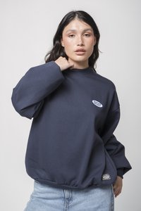 Felpa navy con collo alto, polsini a coste e orlo aderente. Presenta un patch ovale bianco con la scritta "KADIKÖY SOCIETY."