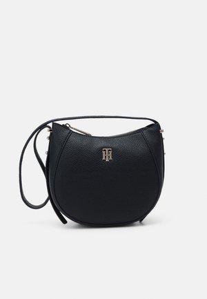 Black textured leather crossbody bag with curved shape, gold-tone zipper, and small gold interlocking initials logo on front.