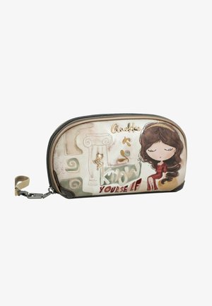Bolsa beige con cremallera con una ilustración de una niña con un vestido rojo, remolinos decorativos y el texto "Anekke Know Yourself" en el frente.