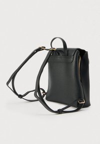 Μαύρο σακίδιο πλάτης από δέρμα με υφή πετρωμάτων, με επάνω λαβή, δύο ρυθμιζόμενους ιμάντες ώμου και μια τσέπη με φερμουάρ στο πλάι. Λεπτομέρειες από υλικό χρυσού τόνου.