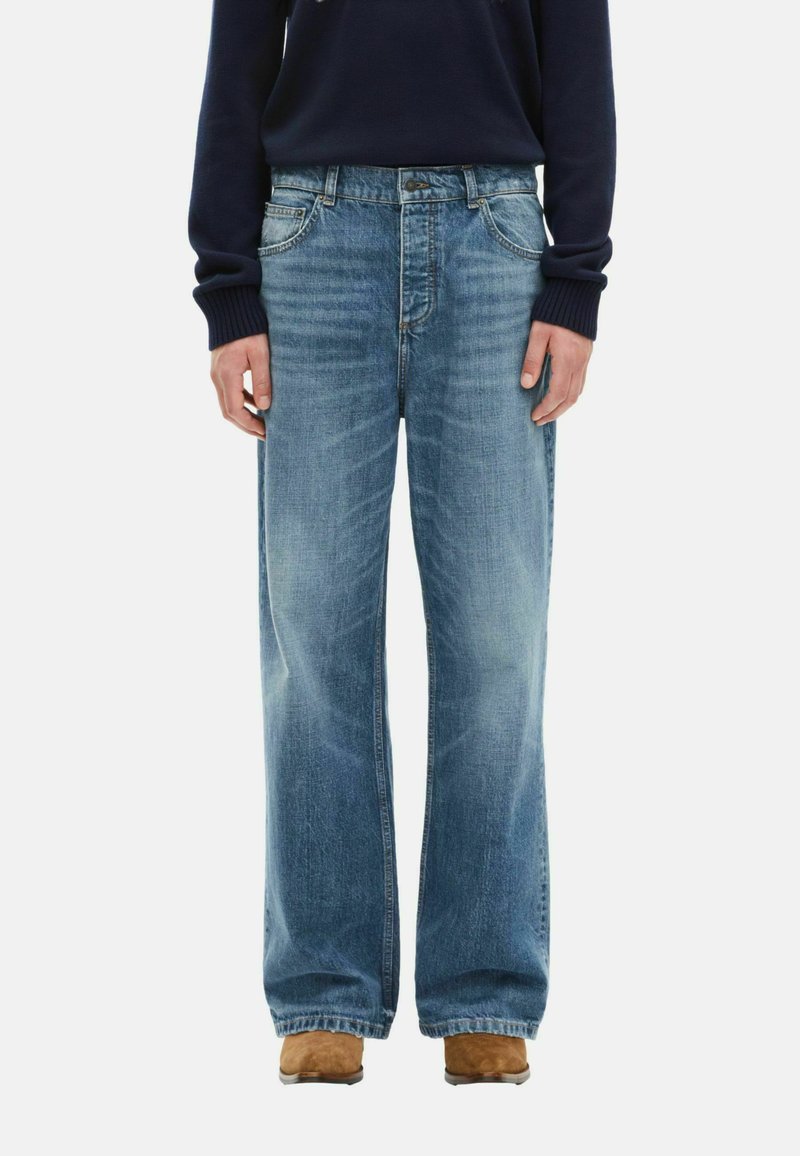 Jeans a gamba larga di un blu chiaro in denim sbiadito, caratterizzati da un classico design a cinque tasche e una chiusura standard con bottone e zip.