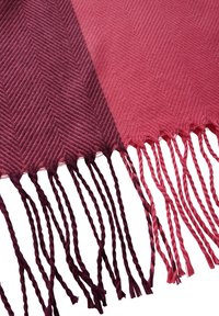 Gewebte Tagesdecke in sanften Abstufungen von Burgunderrot und Rosa, mit einem strukturierten Fischgrätenmuster und fransigen Kanten.