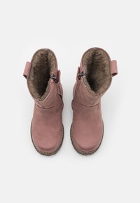 Rosa Lederstiefel mit Kunstfellfutter, abgerundeten Spitzen und einem seitlichen Reißverschluss. Ausgestattet mit einer sandfarbenen Gummisohle und einer kleinen Schlaufe an der Rückseite für einen einfachen Einstieg.