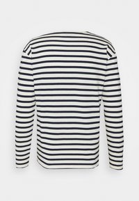 Langarmshirt in Creme mit navyblauen horizontalen Streifen, ausgestattet mit einem einfachen Rundhalsausschnitt und geradem Schnitt. Weiche Stoffstruktur.