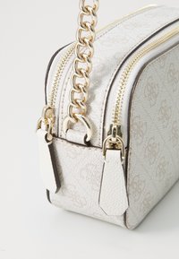 Borsa a mano bianca con motivo, caratterizzata da una forma strutturata, dotata di accessori in oro e di una tracolla a catena. Include cerniere e dettagli in pelle.