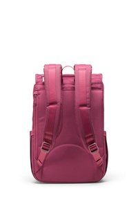 Vista posteriore di uno zaino in tessuto rosa con spallacci imbottiti regolabili, maniglia superiore e tasca laterale con zip, caratterizzato da una trama liscia e forma rettangolare.