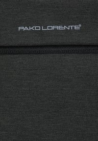 Czarna tkanina o gładkiej fakturze z poziomą szwem oraz logo "PAKO LORENTE" w szarym druku w pobliżu góry.