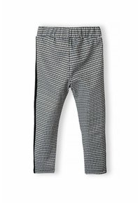 Leggingi v črno-belem houndstooth vzorcu z elastičnim pasom in kontrastnima črnima stranicama, izdelani iz gladkega, teksturiranega blaga.
