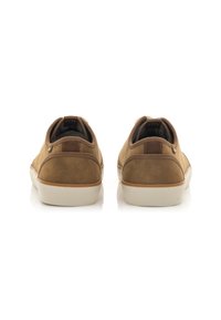 Scarpe in suede marrone con design a bassa punta, suola in gomma bianca e un piccolo accento in pelle marrone sul tallone. Superficie testurizzata con cuciture minime.