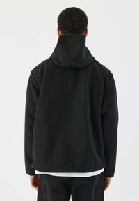Giacca nera con cappuccio, dalla texture liscia, vestibilità comoda e orlo stretto. Il design presenta un colletto alto e uno stile minimalista.