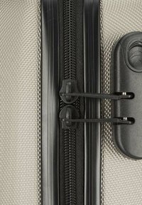 Textured gray fabric with a black zipper, featuring two zipper pulls and a plastic closure mechanism nearby.