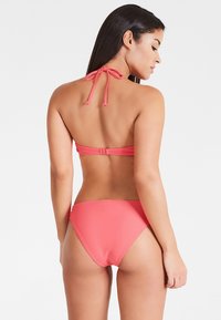 Koralle Bikini mit Halterneck-Bindung, verstellbarem Rückenverschluss und glattem, dehnbarem Stoff. Enthält einen niedrig sitzenden Bikini-Unterteil.
