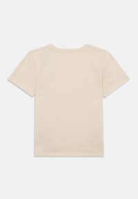 Ανοιχτό μπεζ βαμβακερό μπλουζάκι με κοντά μανίκια, στρογγυλή λαιμόκοψη και καθαρές ραφές. Χωρίς μοτίβα ή γραφικά στην πλάτη. Απλή, λείος υφή.