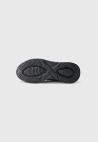 Sole of a black sneaker showing tread pattern with oval and linear grooves, and an "EA7 Emporio Armani" logo on the heel area.