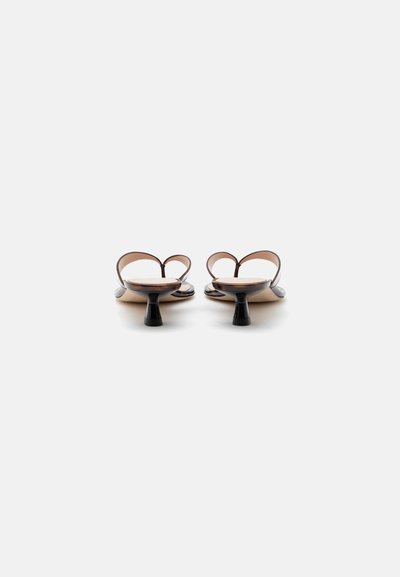 Paire de sandales marron à brides avec petits talons kitten et orteils ouverts, vues de dos sur fond blanc.