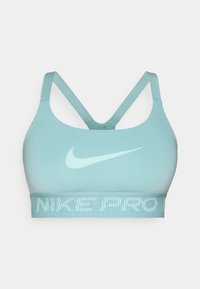 Svijetloplava sportska grudnjak s tankim ukriženim trakama i bijelim Nike swooshom te tekstom "Nike Pro" na elastičnoj traci ispod grudnog koša.