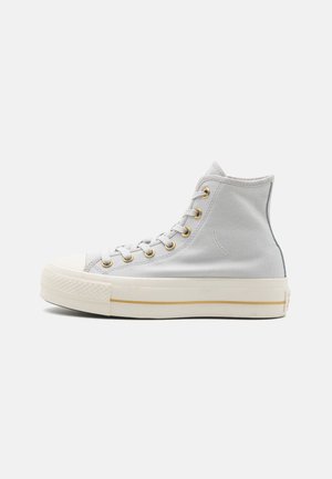 Hohe Sneaker aus hellgrauem Canvas mit goldenen Ösen, einer weißen Gummikappe und einer weißen Sohle mit einem goldenen Streifen.