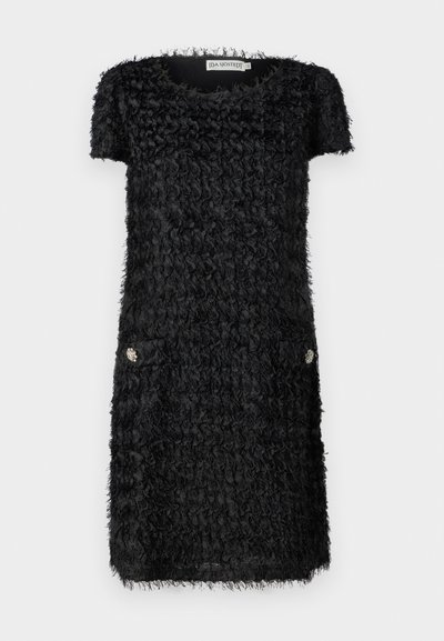 Fekete ruha rövid ujjakkal, texturált anyagból, fodros részletekkel és két elülső zsebbel, díszes ezüst kiegészítőkkel.